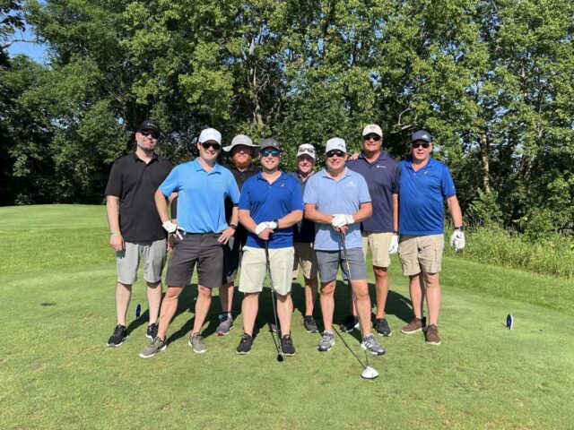 A group of golfers pose together on the course during the 25th annual Wright County Golf Tournament.