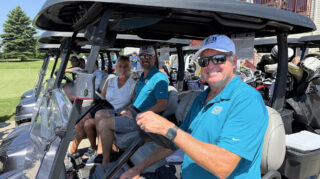 Golfers smile from their cart before teeing off at the annual Wright County Golf Tournament in Buffalo, MN.