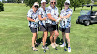 Women golfers enjoy drinks at a tiki-themed stand during the Wright County Golf Tournament.