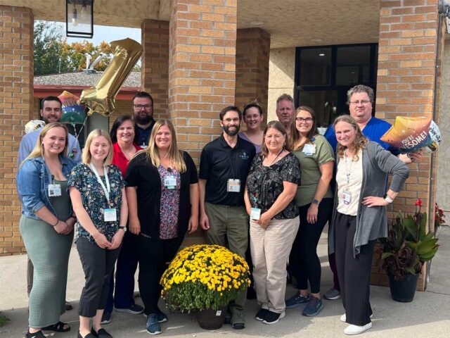 Lake Ridge Health Care Center staff in Buffalo, Minnesota, celebrate being ranked No. 1 in Minnesota Quality Measures for 2025, standing together outside the care center with balloons and flowers.