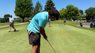Participant putts on a practice green during the Community Health Foundation of Wright County Golf Tournament in Buffalo, Minnesota.